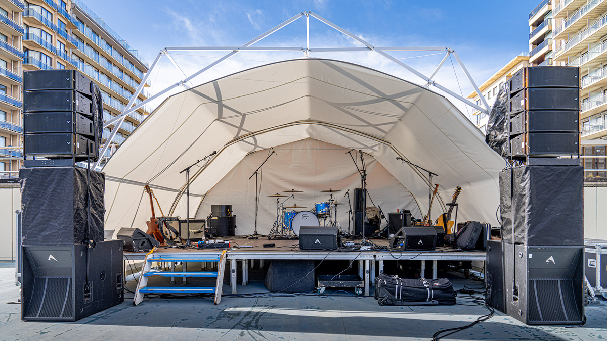 Konligo Fastival event structure with full white inner backdrop and membrane used as a covered outdoor stage setup with musical instruments and speakers, now available on MTN SHOP US. - imagen 7