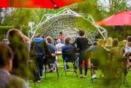 Konligo Fastival event structure with custom printed green foliage membrane and printed backdrop, hosting a live outdoor performance at My Garden Fest, now available on MTN SHOP US. - imagen 11