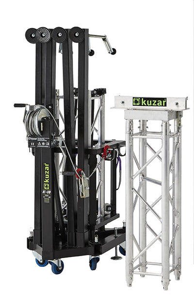 Kuzar K-10 Traversenlift im zusammengeklappten Transportzustand mit Lenkrollen neben einer Traversensektion
