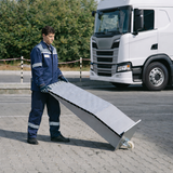 ALTEC Aluminium-Auffahrkeil auf Asphalt, von Person transportiert, Lkw im Hintergrund